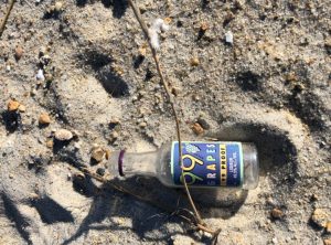 Empty nip bottle on beach